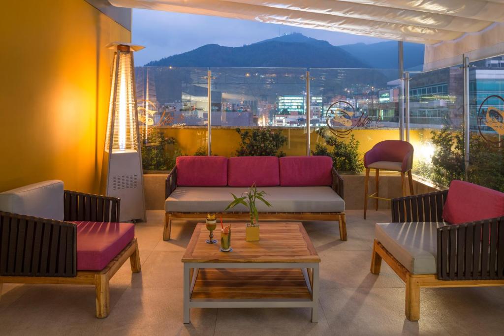 a living room with a couch and chairs and a table at Hotel El Dorado Bogota in Bogotá