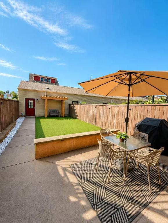 a patio with an umbrella and a table and chairs at Family-Friendly 4BR Retreat Sleeps 12, Private Yard, Garage, Close to Stadiums, Casino & Downtown in Pittsburgh