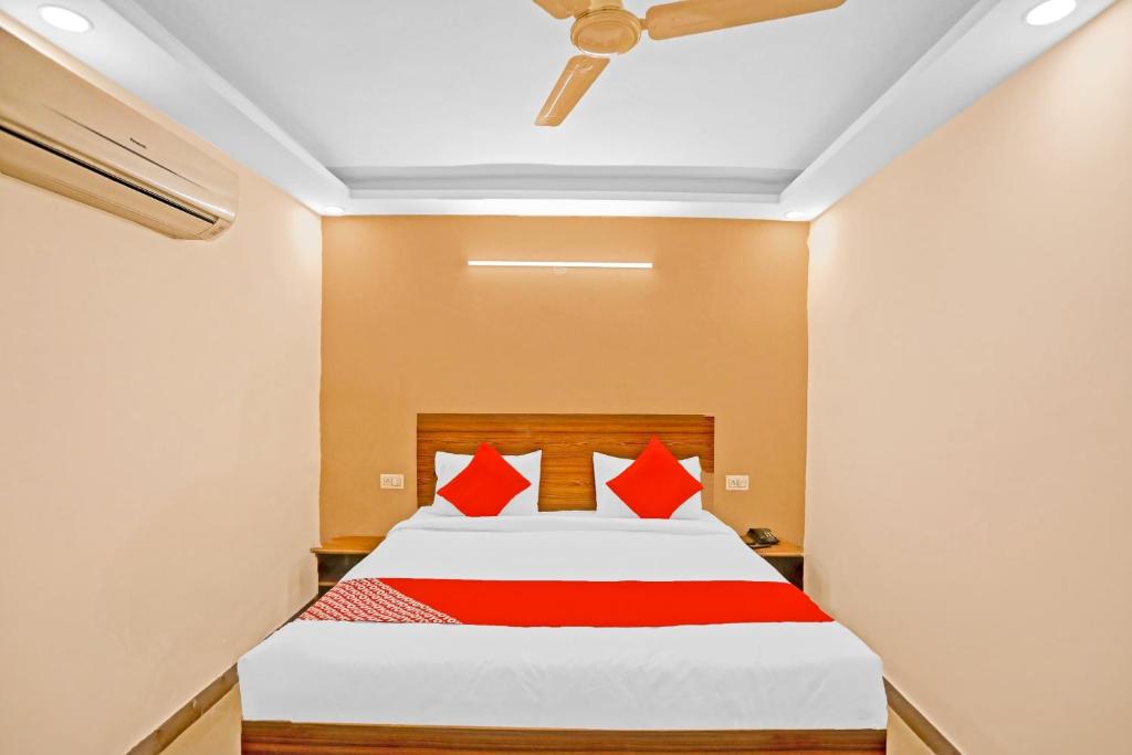 a bedroom with a bed with red pillows at Hotel O Happy Spring in New Delhi