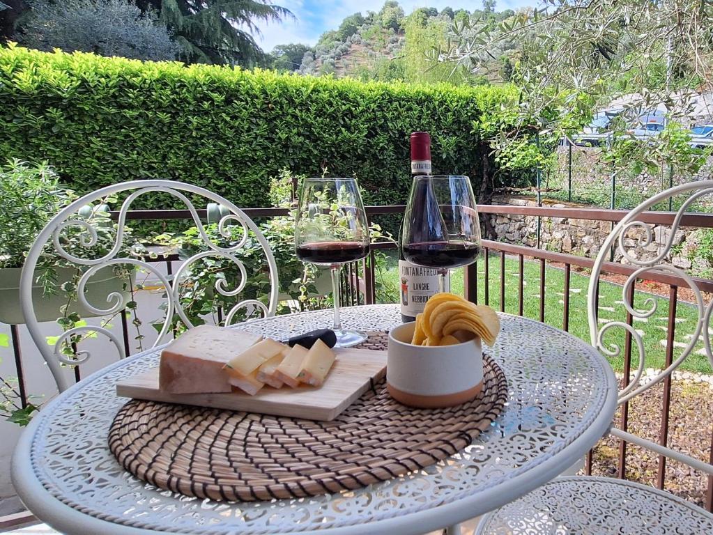 a table with a glass of wine and cheese at Il Giardinetto in Riva di Solto