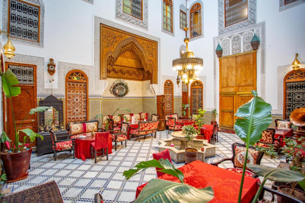 a lobby with red chairs and tables and a building at Riad Fes iline Medina in Fez