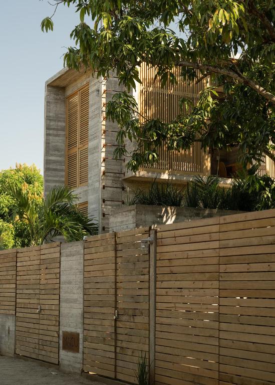 a wooden fence in front of a building at Casa Macu Boutique Homes in La Salada