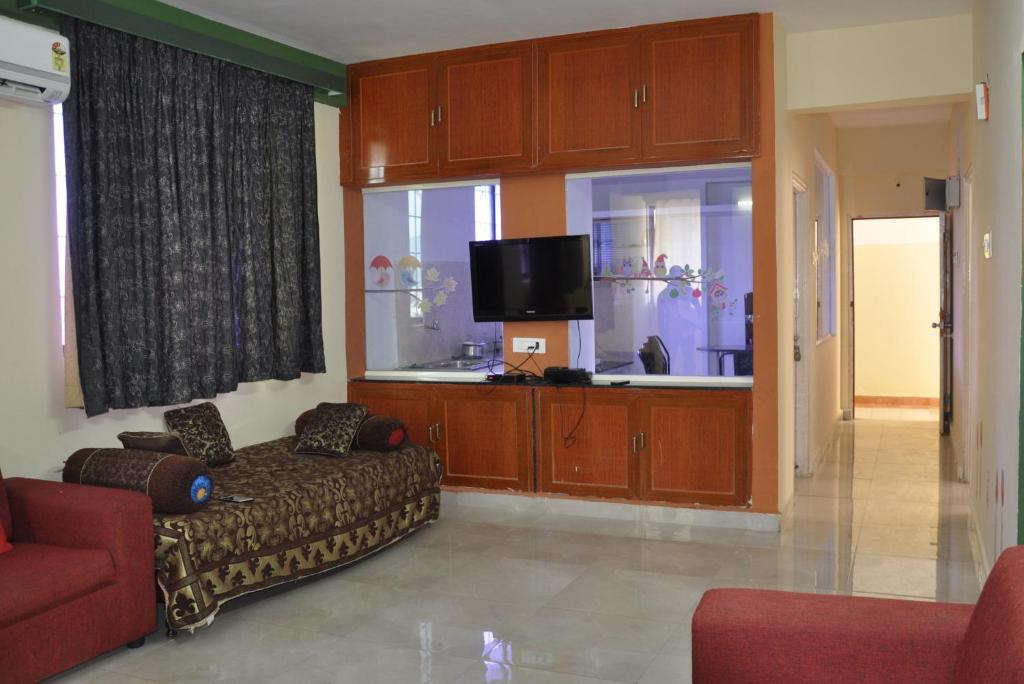 a living room with a couch and a flat screen tv at Nayath Serviced Apartments in Tirupati