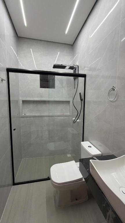 a bathroom with a shower and a toilet and a sink at Casa moderna próximo ao bumbodromo in Parintins