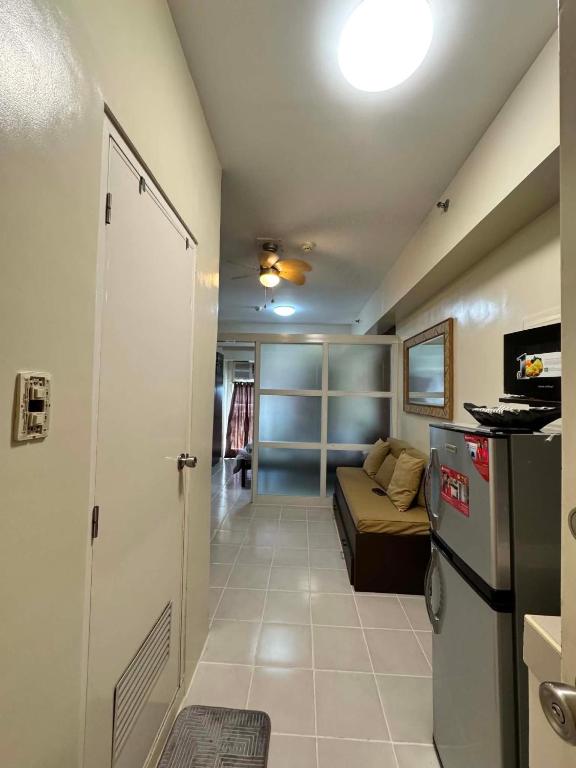 a small living room with a couch and a refrigerator at Maldee's Place Tagaytay Prime Residences in Tagaytay