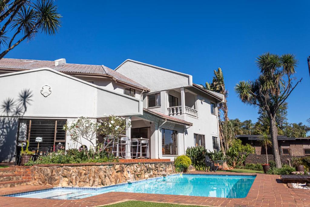 a house with a swimming pool in front of a house at The Bedford View Guest House in Germiston