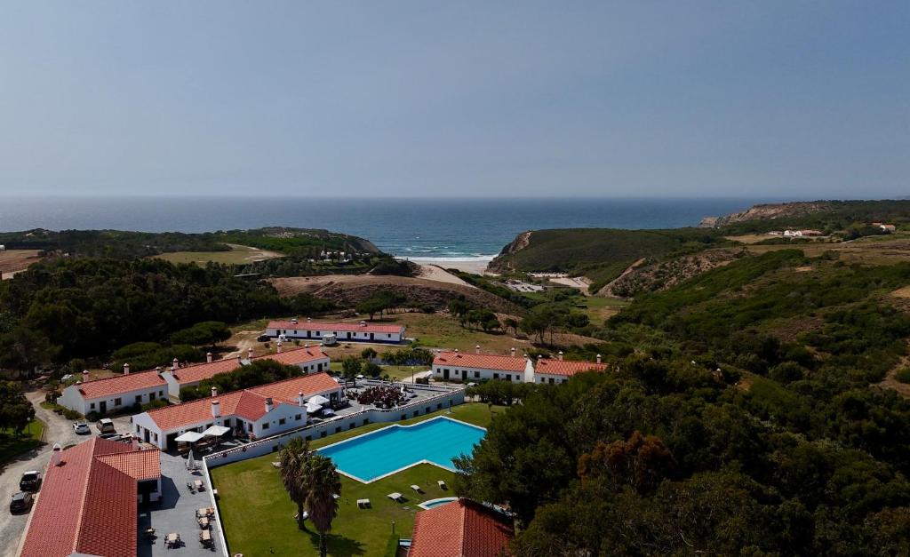 an aerial view of a resort with a swimming pool and the ocean at Monte Carvalhal da Rocha in Zambujeira do Mar