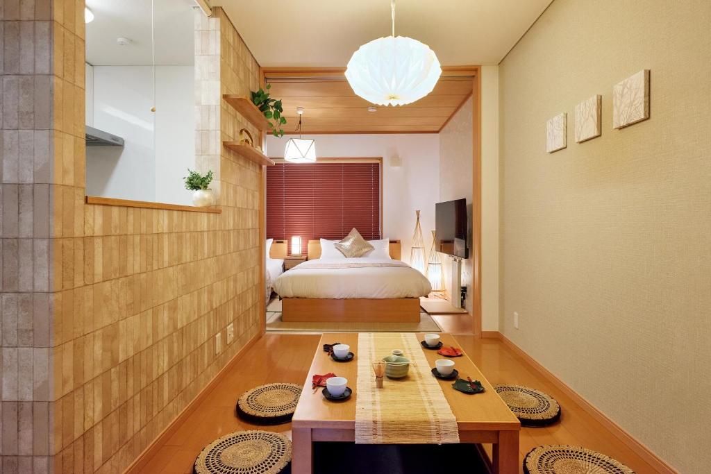 a bedroom with a bed and a table in a room at R STAY Nagoya Juocho in Nagoya