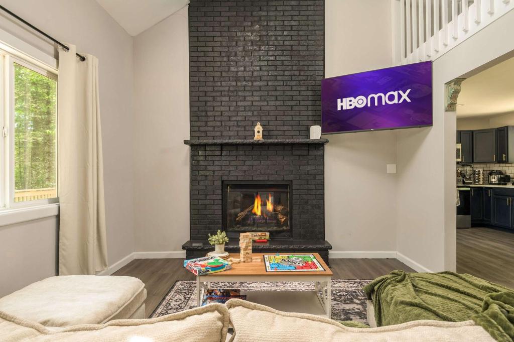 a living room with a fireplace and a sign that says houston at Tucked in the Woods - Jacuzzi Firepit Pooltable in Long Pond