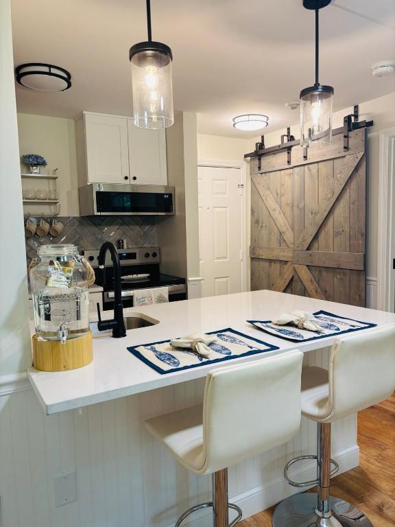 a kitchen with a white counter and a barn door at New Cape Cod Condo Near Beaches in Brewster