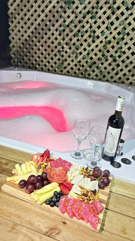 a cutting board with a bottle of wine and wine glasses at Apartamento La bonita guatape in Guatapé