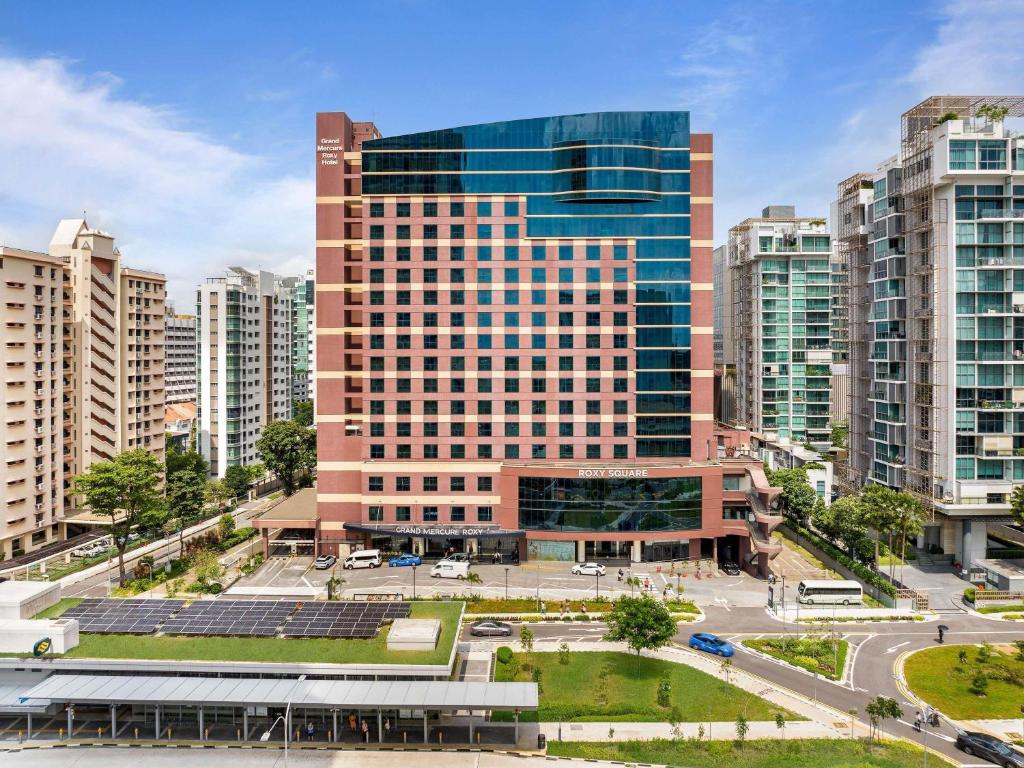 a large building in a city with tall buildings at Grand Mercure Singapore Roxy in Singapore