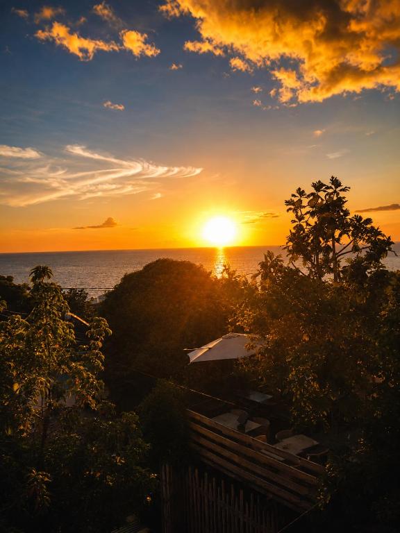 a sunset over the ocean with the sun in the sky at Tidododesiles in Bouillante