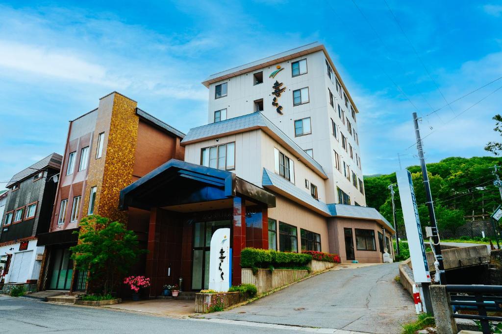 a tall white building on the side of a street at ZAO SPA HOTEL Kiraku in Zaō Onsen