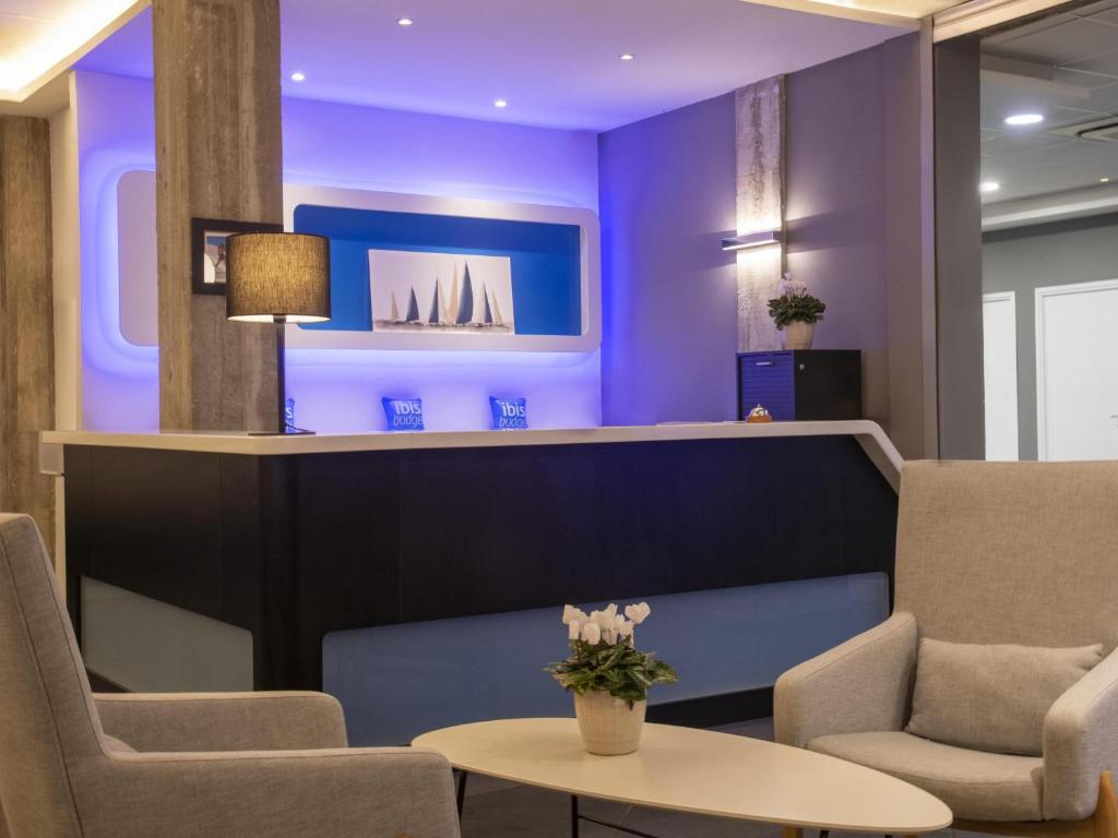 a lobby with purple walls and a table and chairs at ibis budget Ajaccio in Ajaccio