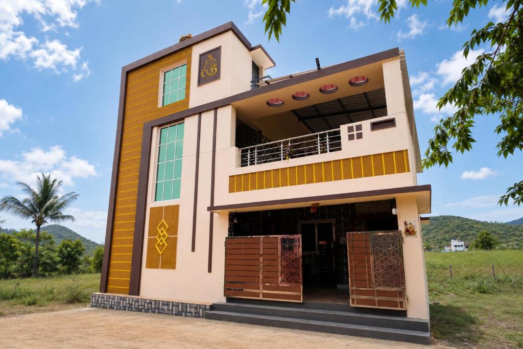 a house in the middle of a field at Malar Resort in Wodapatti