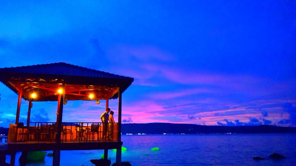 a person standing on a pier at night at Samloem Laguna Resort in Koh Rong Sanloem