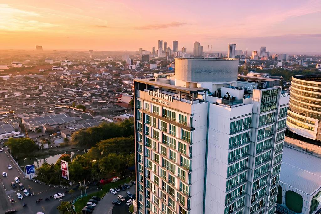 an aerial view of a tall building with a city at Midtown Residence Surabaya in Surabaya