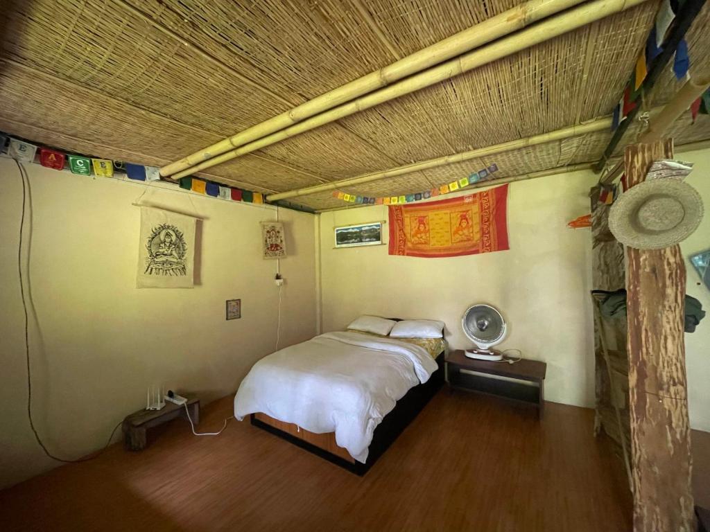 a bedroom with a bed and a ceiling with flags at Organic Retreats in Pokhara