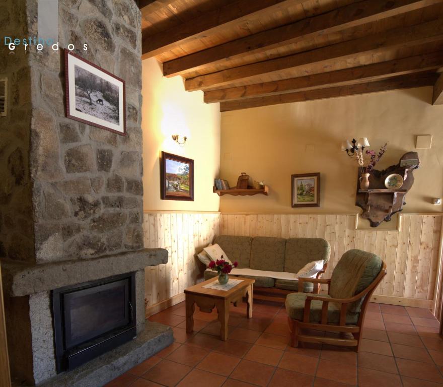 sala de estar con chimenea y sofá en Casa Rural Valdeascas, en Navarredonda de Gredos