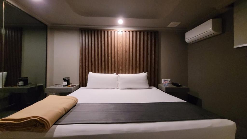 a bedroom with a large bed with white sheets at Real La Viga Motel in Mexico City