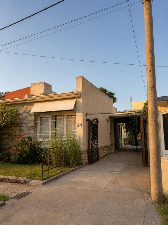 an old house with a driveway in front of it at CASA MENDIOLA, encantadora casa con patio privado, y pileta en jardín cerca de la Laguna in Chascomús