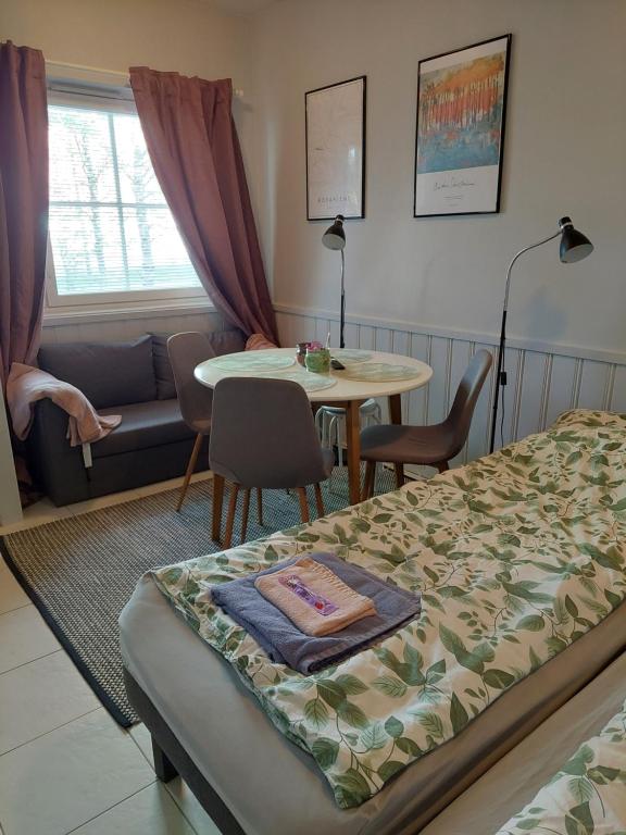 a bedroom with a bed and a table and a couch at Levistar studio with sauna in Levi
