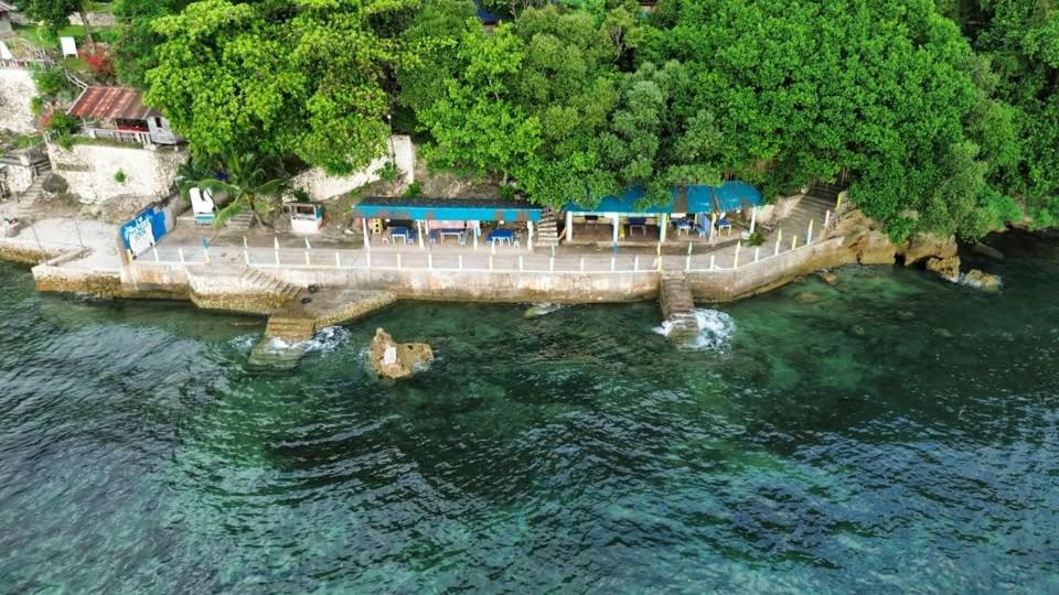 a bridge over the water with tables and blue umbrellas at Monique Beach Resort by Hiverooms in Carmen
