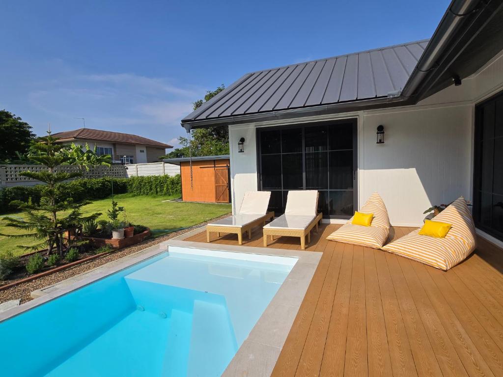 a backyard with a swimming pool and a house at DRIZZLE pool and pillows in Phra Khanong