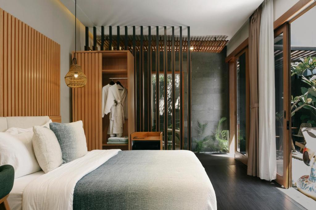 a bedroom with a large bed and a dressing room at Villa Di Bali in Yogyakarta