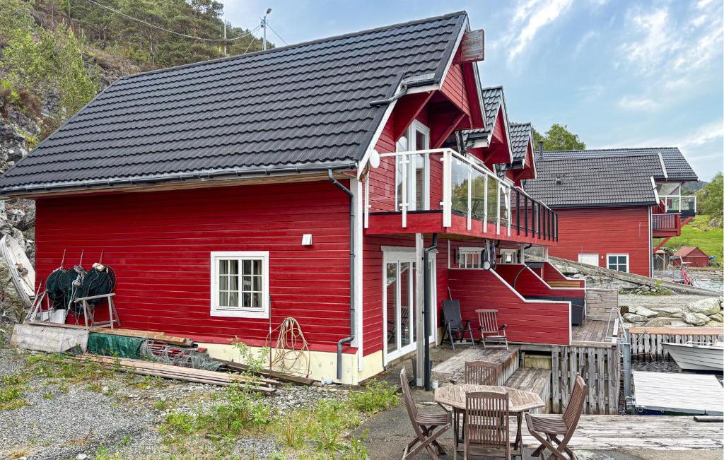 a red house with a table and chairs in front of it at 3 Bedroom Nice Home In Os in Oma