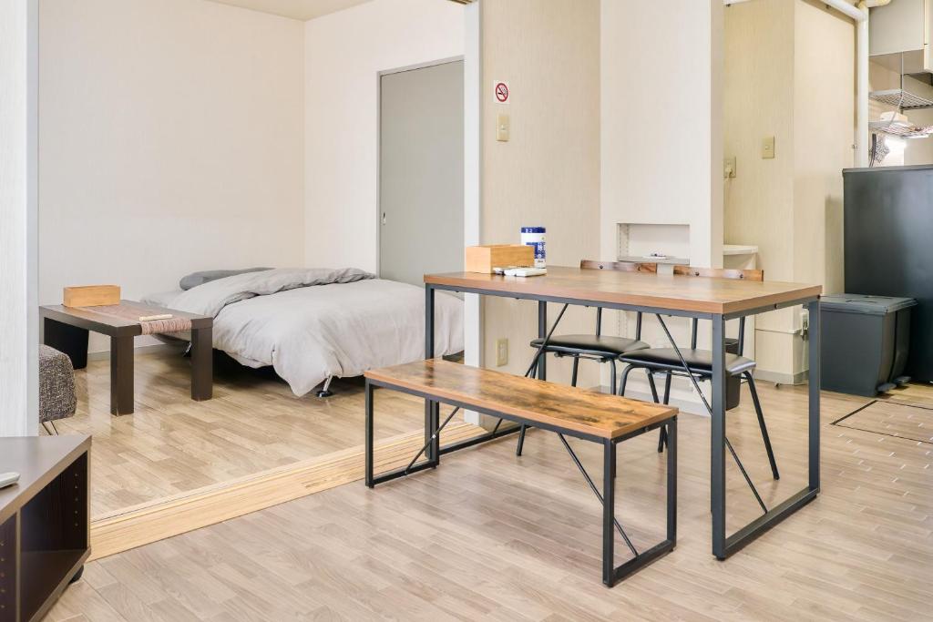 a room with a bed and a desk and a table at Bird Heights 101 in Furano