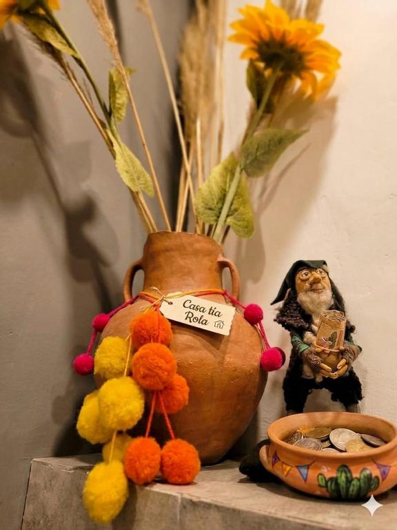 a cat sitting next to a vase with flowers at La Tía Rola in Humahuaca