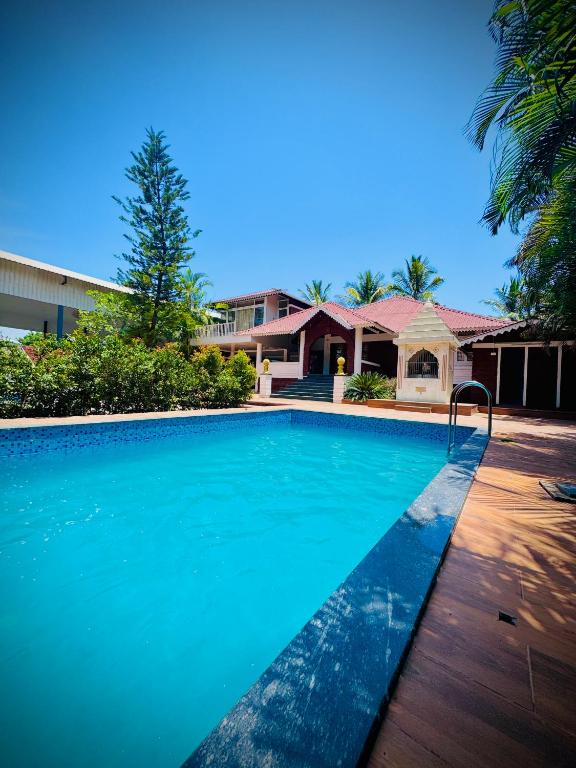 a swimming pool in front of a house at Siddhi farm in Kolhapur