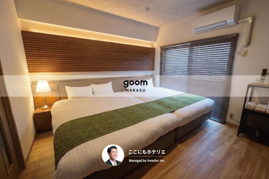 a hotel room with a bed with a poster on it at goom Hotel Nakasu in Fukuoka