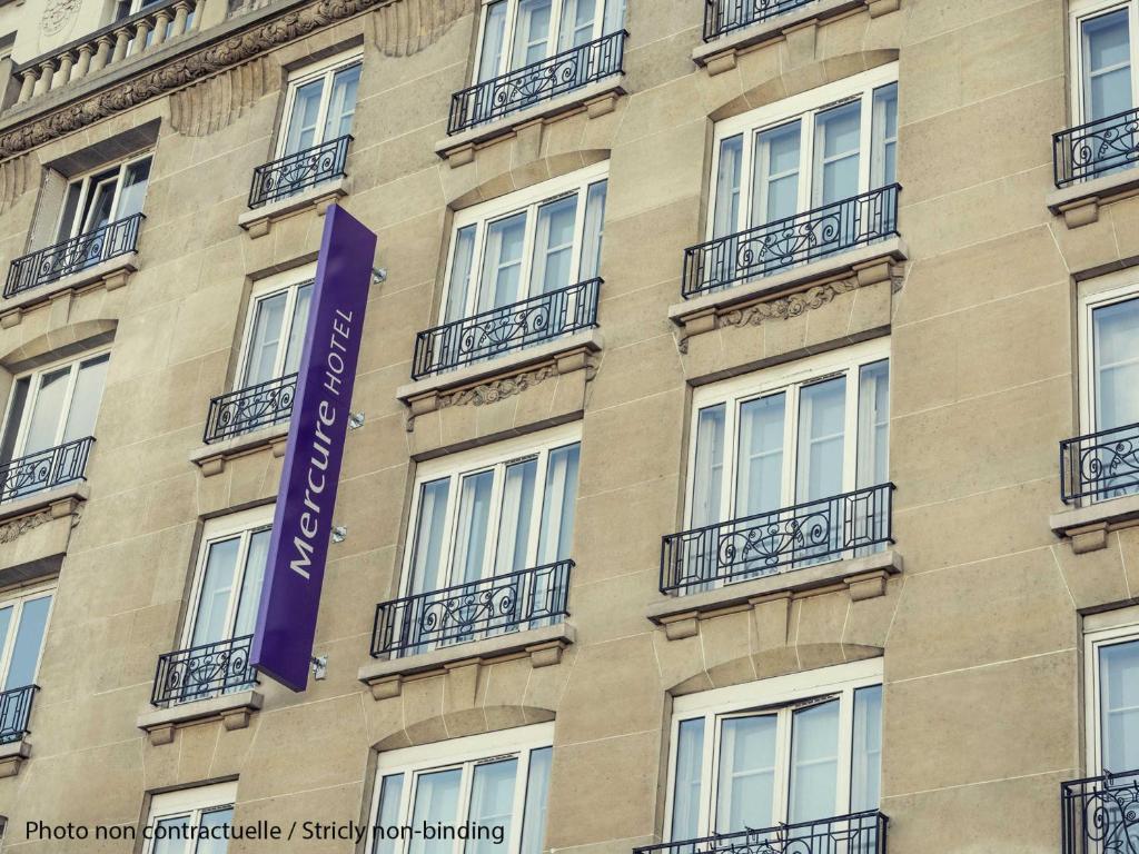 a building with a purple sign on the side of it at Hôtel Mercure Marne-la-Vallée Bussy St Georges in Bussy-Saint-Georges