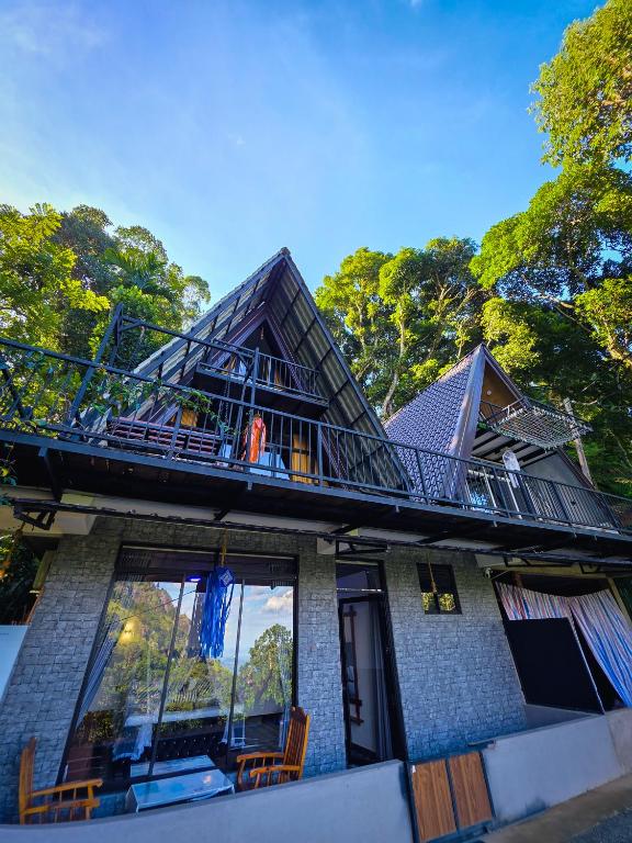 a person standing on the balcony of a house at White Moon Cabin & Cottage in Ella