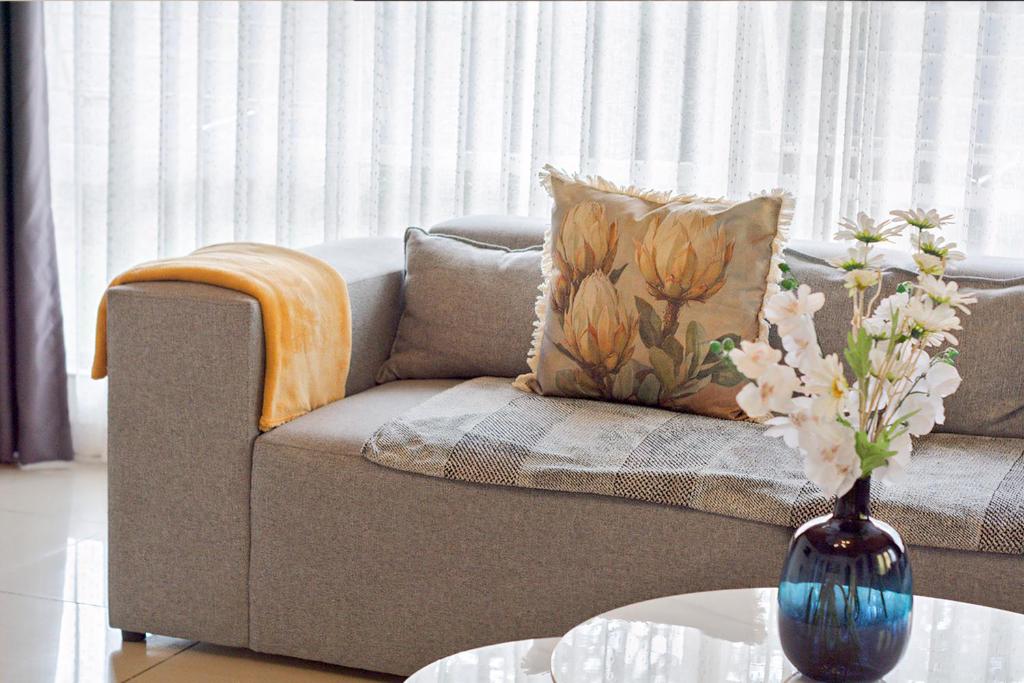 a living room with a couch and a vase with flowers at Elyon Suites in Kempton Park