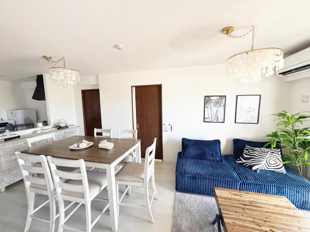 a living room with a table and a blue couch at Maison deLacue in Uruma
