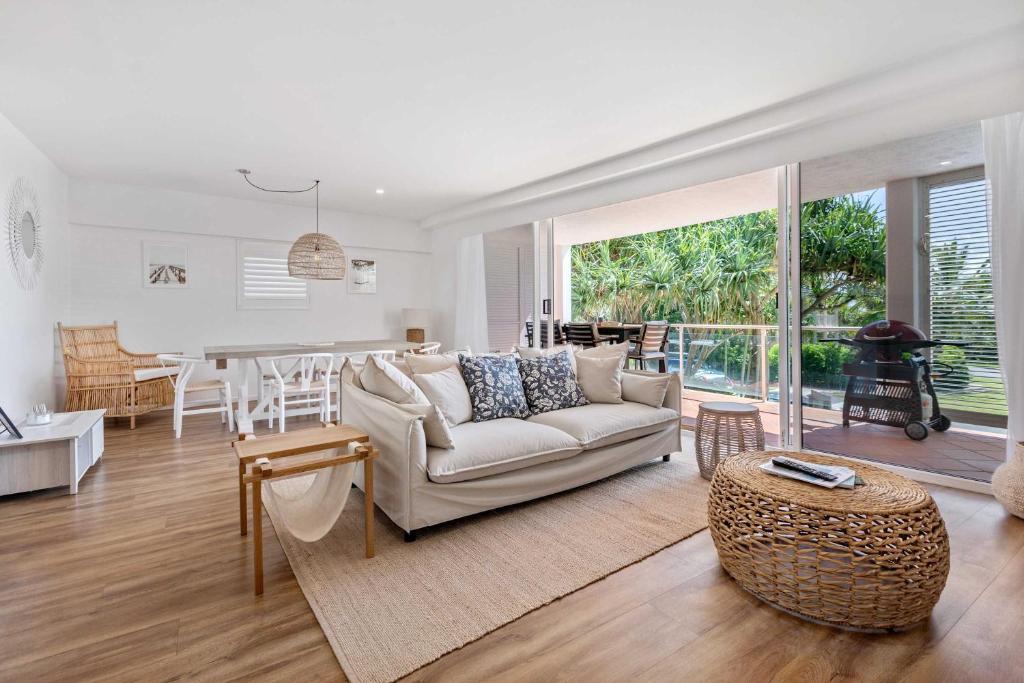 a living room with a couch and a table at Sophisticated & stylish beachside apartment with pool in Sunrise Beach