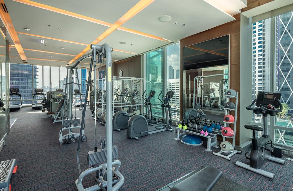A bright, window-lined gym with cardio and strength equipment.