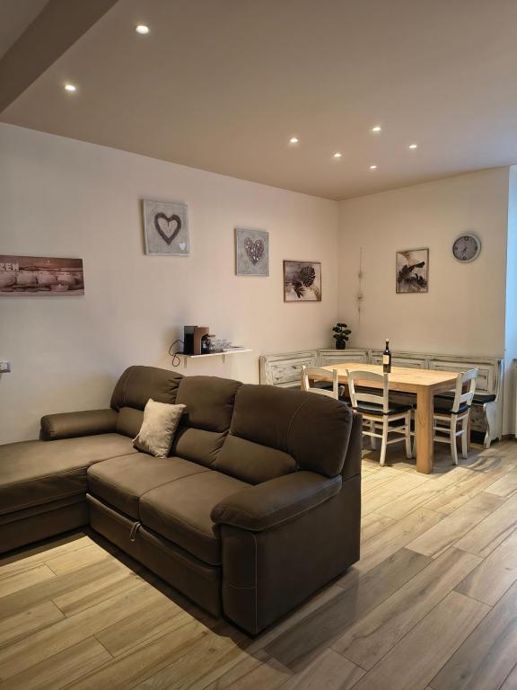 a living room with a brown couch and a table at MaGi-A apartment in Cecina