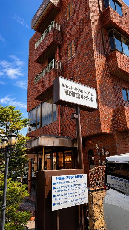 a building with a sign in front of it at 和洲館ホテル in Gyōda
