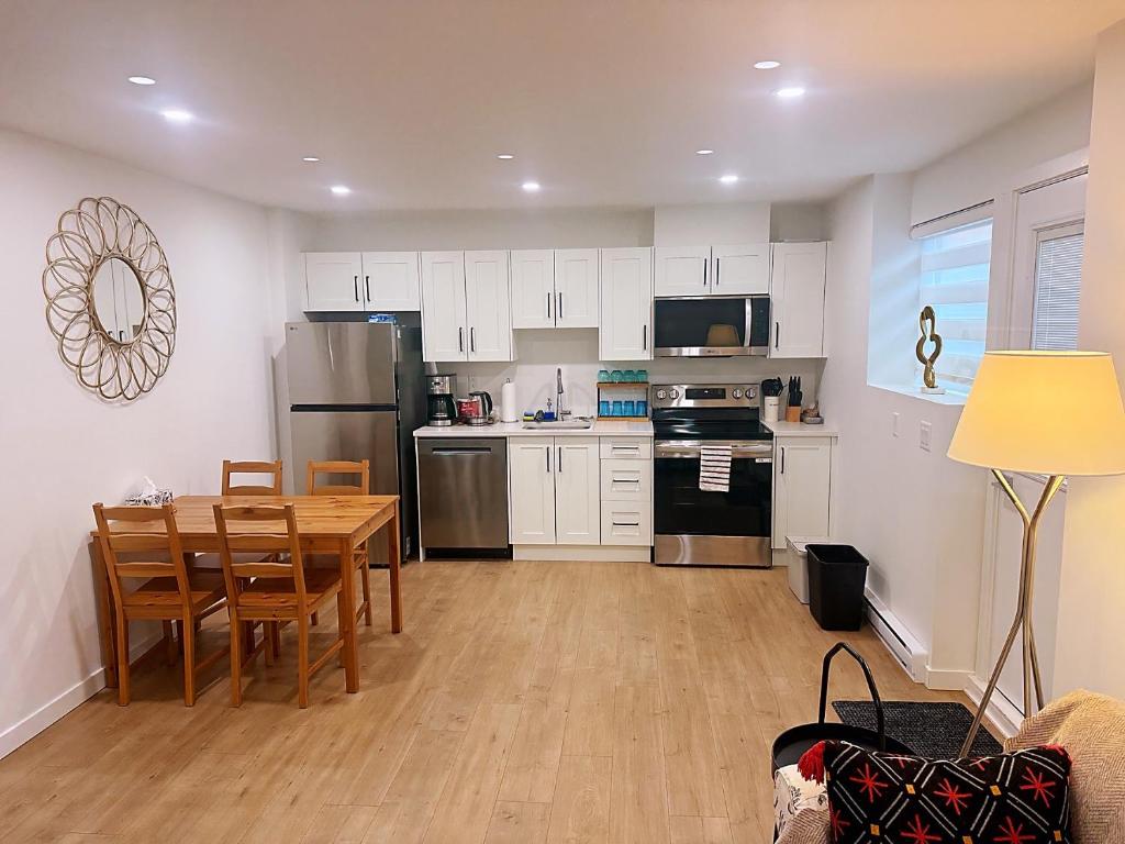 a kitchen with white cabinets and a wooden table with chairs at Kris Anclam in Langley