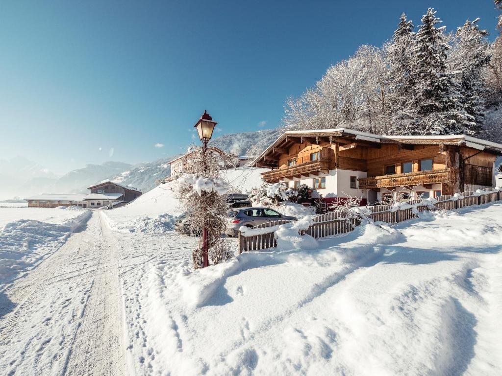 a snow covered house with a street light in front of it at Ferienwohnung Martin in Zellberg