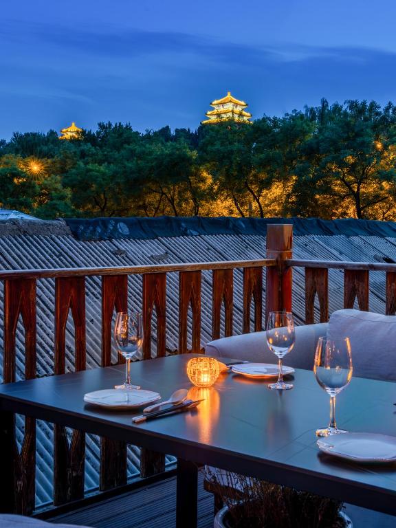 a table with wine glasses on top of a balcony at Jingshan Garden Courtyard Hotel Beijing Forbidden City Newly renovated Tianmen Wangfujing Gardenhutong BejjingCourtyard in Beijing