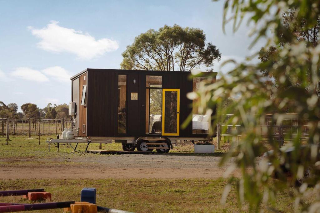 a black tiny house sitting on a trailer at Kookaburra Retreat by Tiny Away in Arcadia