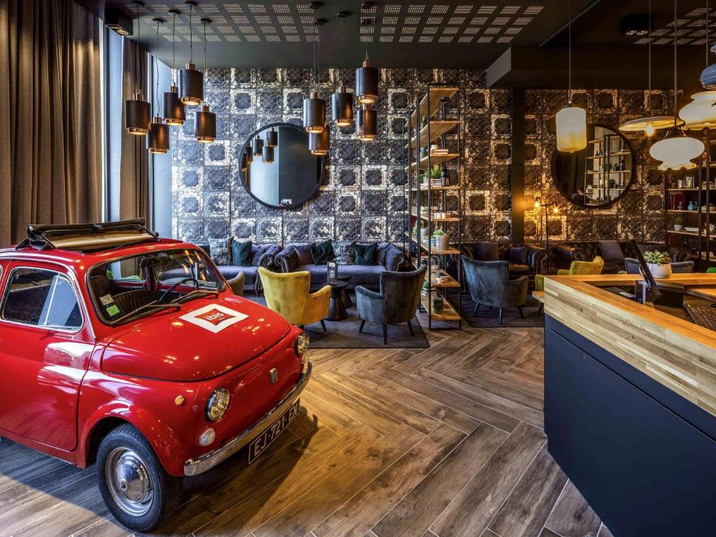 a room with a red car parked in a bar at ibis Le Mans Centre Gare Nord in Le Mans