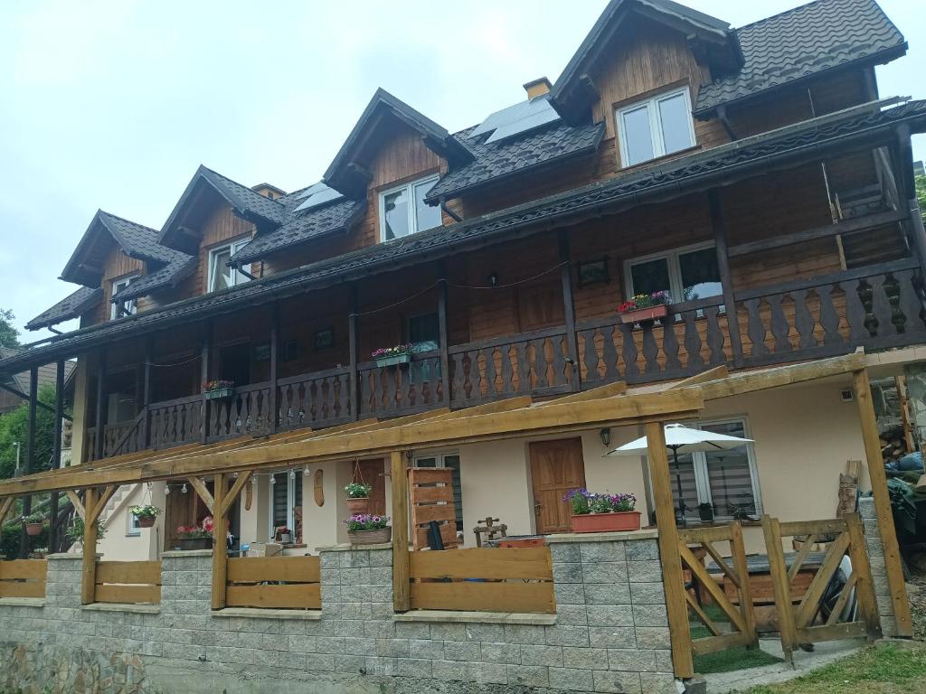 a large wooden house with a balcony at Noclegi ''U Wandy'' in Polańczyk
