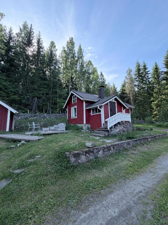 ein rotes Haus mitten auf einem Feld in der Unterkunft Metsäpirtti in Kolinkylä